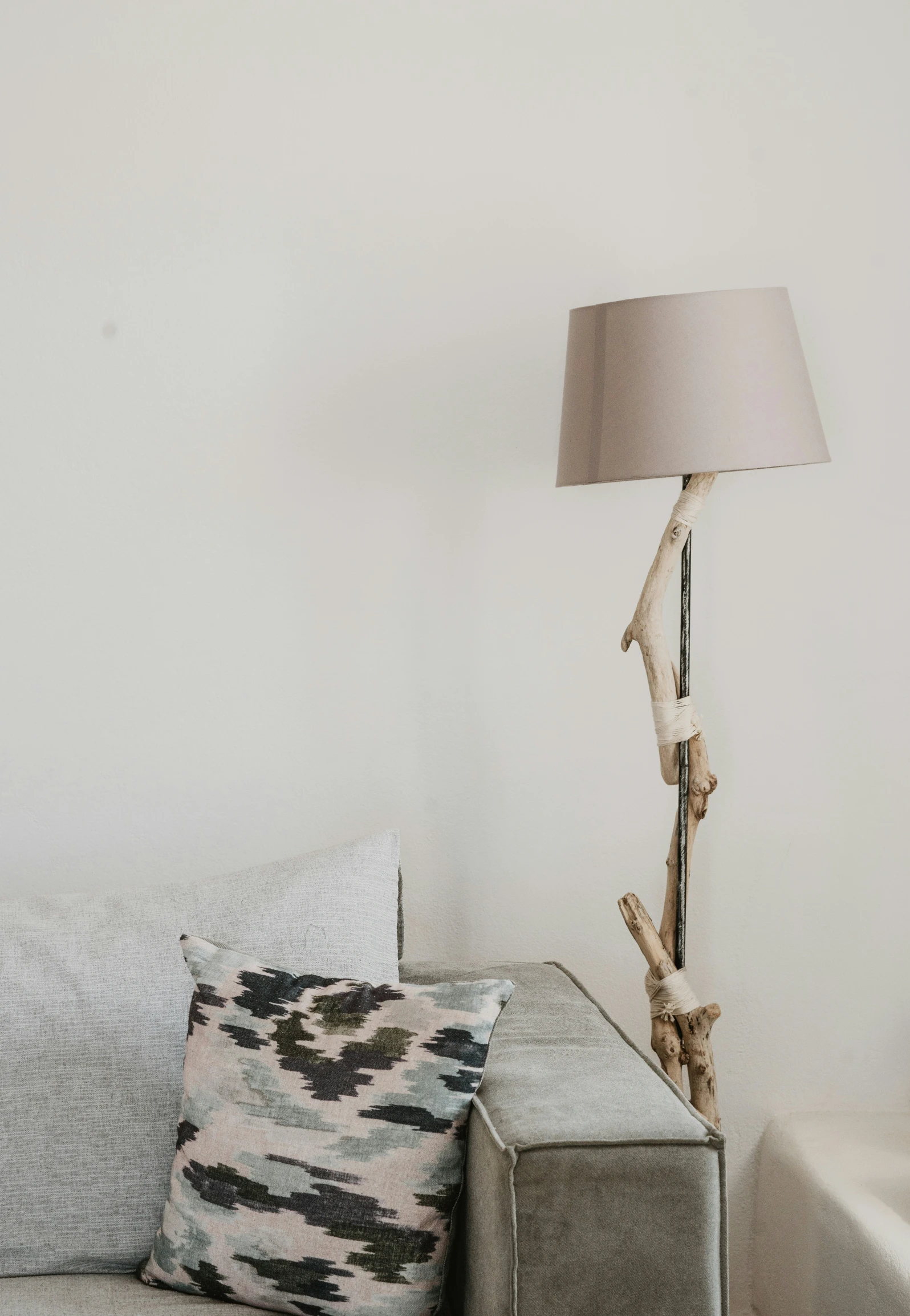 a couch with some pillows and a lamp in a living room