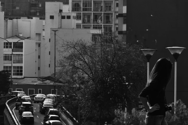 a woman with a umbrella looking over a city road