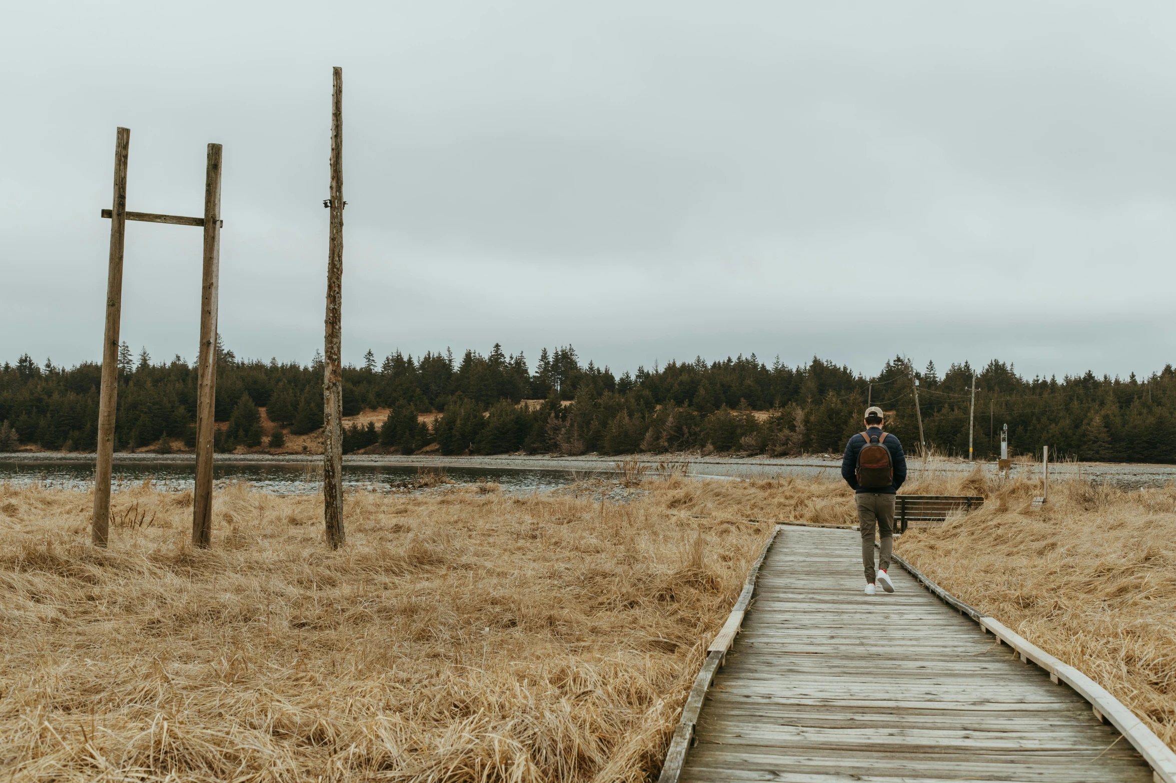 a person with a backpack walking along a wooden path