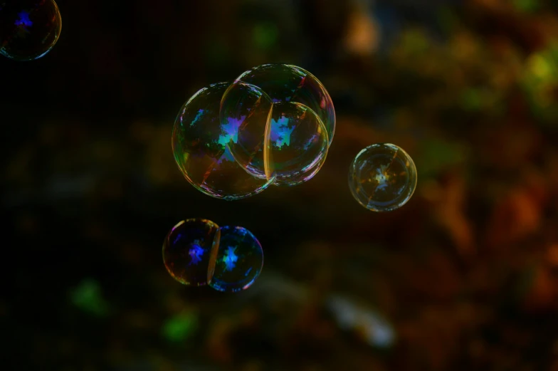 three bubbles of varying shapes floating in the air