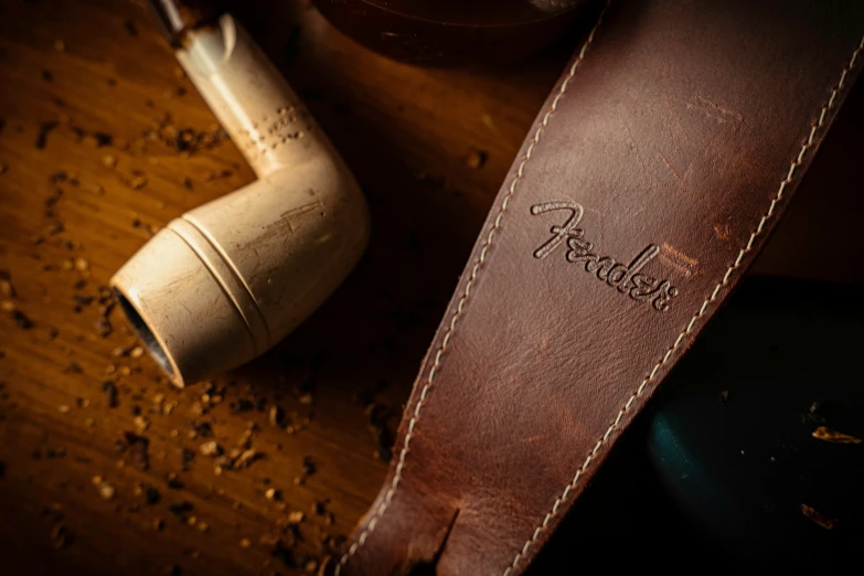 a pipe and some leather things on a table