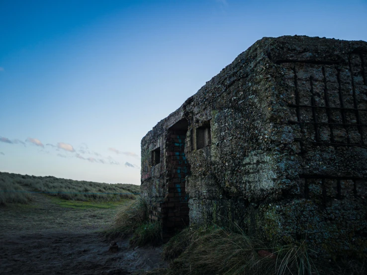 an old stone building in a grassy field