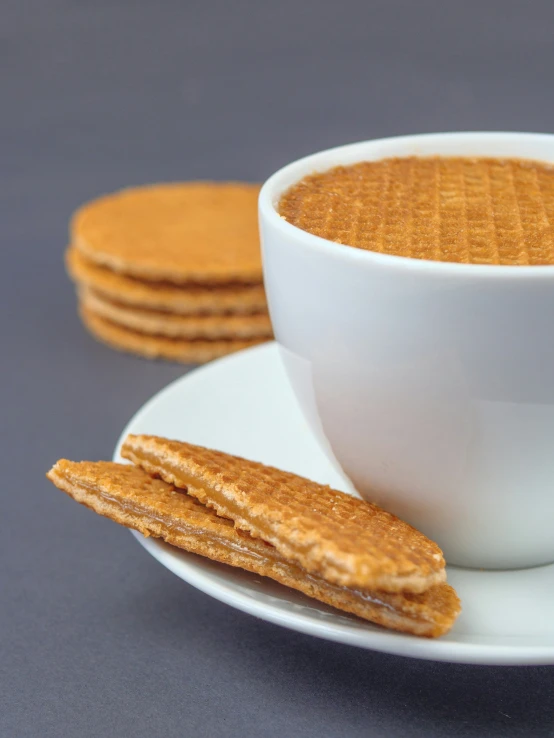 a white plate topped with graham cookies next to a cup of  coffee