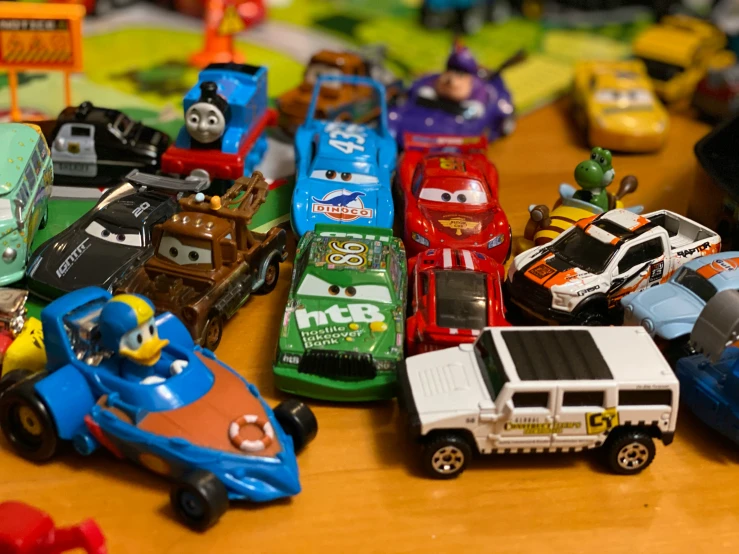 a collection of toy cars displayed on wooden table