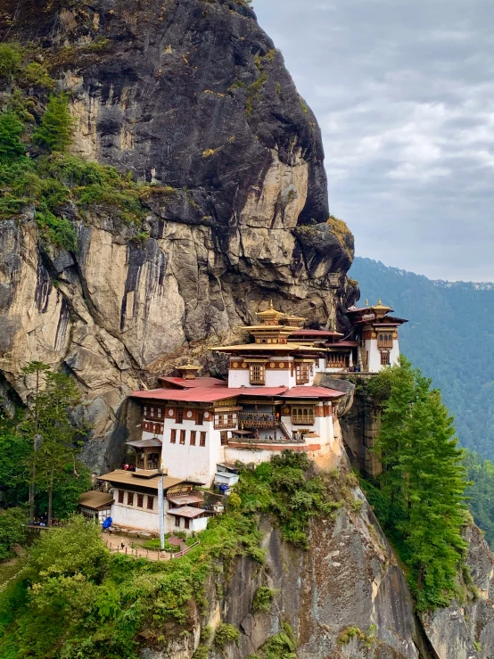 large buddhist building perched on the edge of a cliff