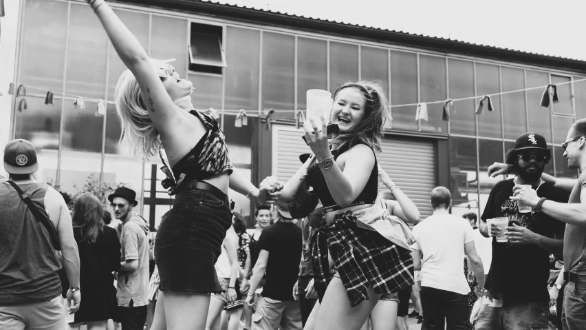 two women standing side by side, reaching up into the air