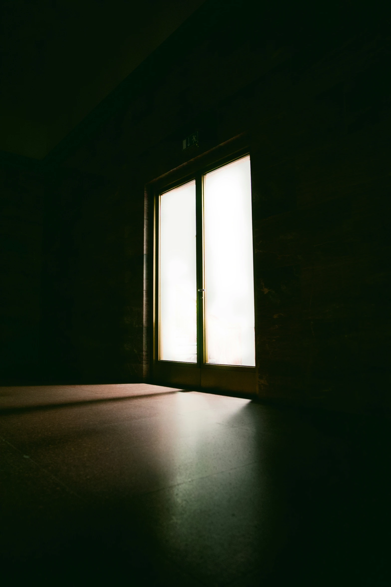 a dark room with an empty window and floor