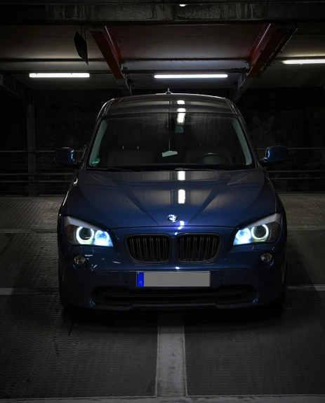 an illuminated bmw car sits in a parking lot