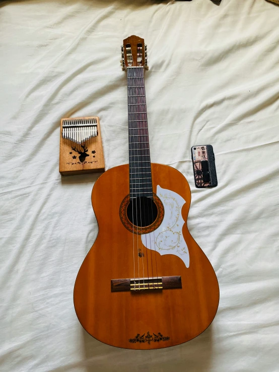 an electric guitar and other electronic devices sit on top of a bed