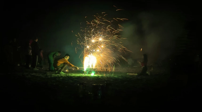 people standing around an open field watching fireworks