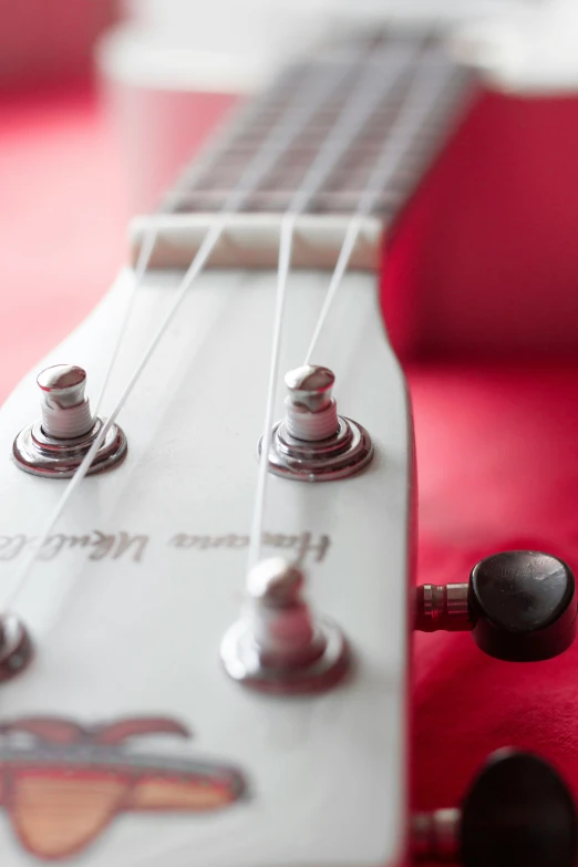 an electric guitar sits on a red surface