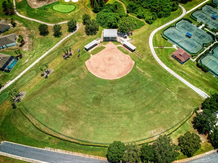 an aerial view of a baseball field in the middle of town