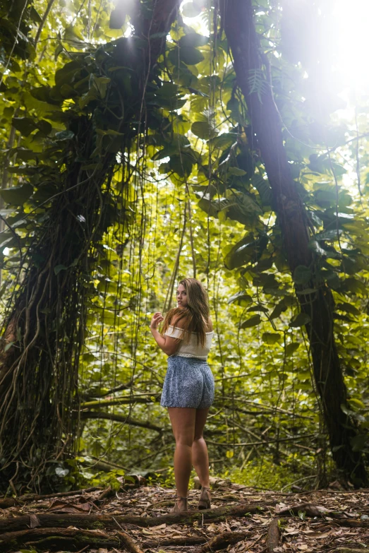 the young woman is holding onto ropes that are hanging from the trees