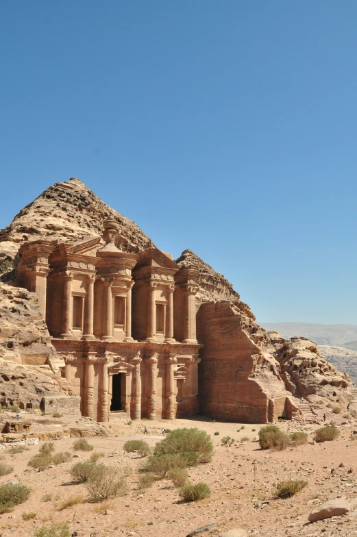 a very large building sitting in the middle of some sand