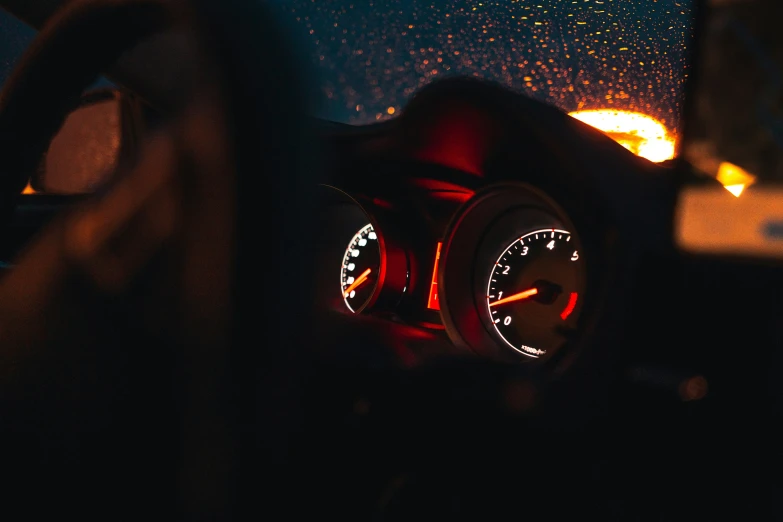 a dashboard showing the time is set on a rainy night