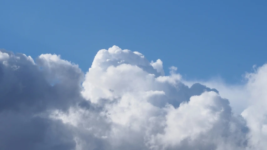 a plane flying through the sky on cloudy day