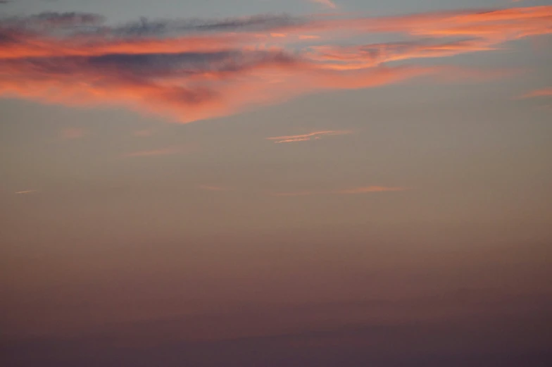 a plane is flying away from the setting sun