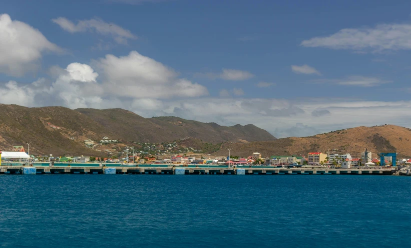 the view of a long pier that is under a cloudy sky