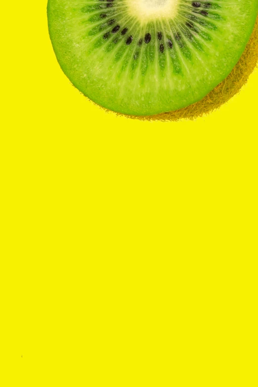 a kiwi is placed on a yellow surface