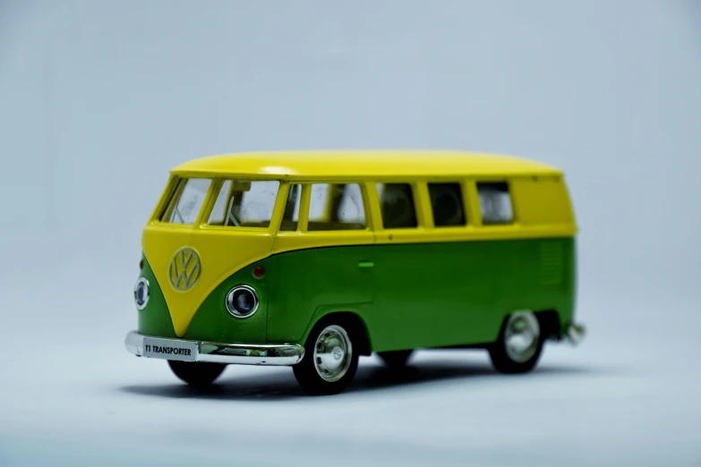 small yellow and green van sitting on top of a white floor