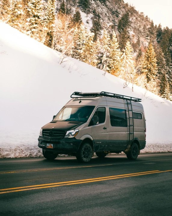 the brown van is on the side of a snowy road