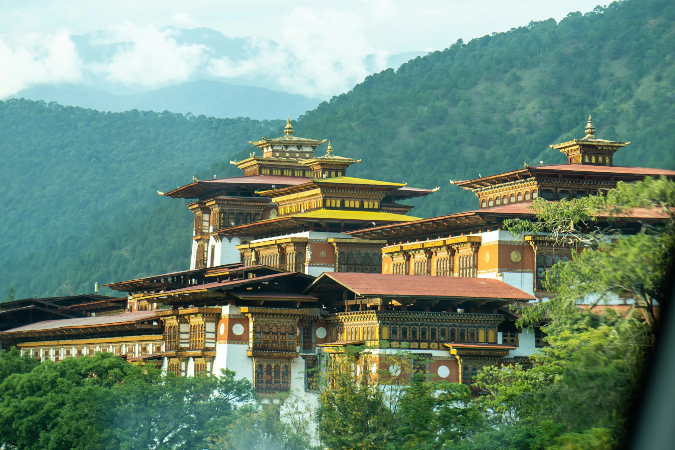 a temple sitting on top of a lush green hillside