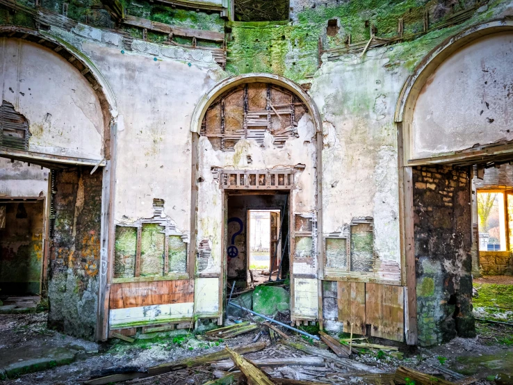 the dilapidated interior of an abandoned building with a doorway in between it