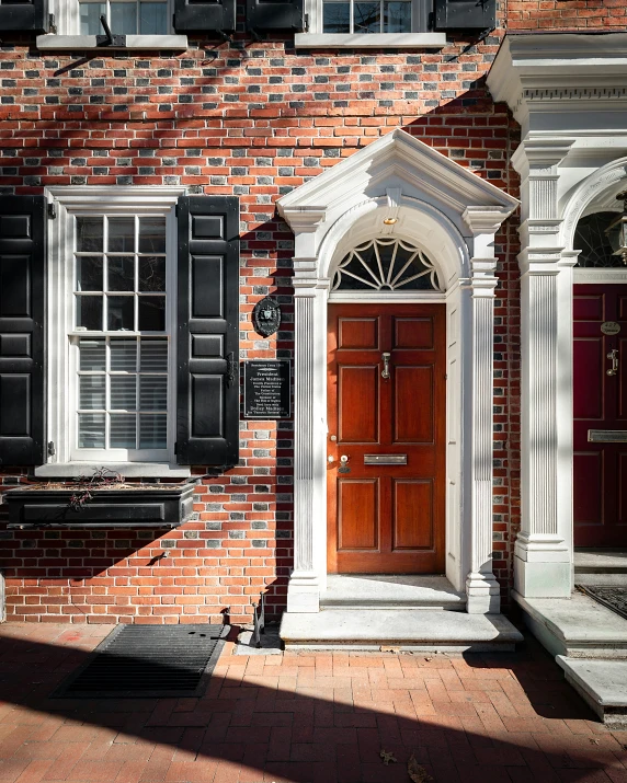 a tall brick building with shutters and red doors