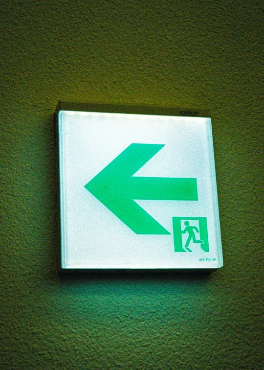 the square arrow sign is on top of a square white plaque