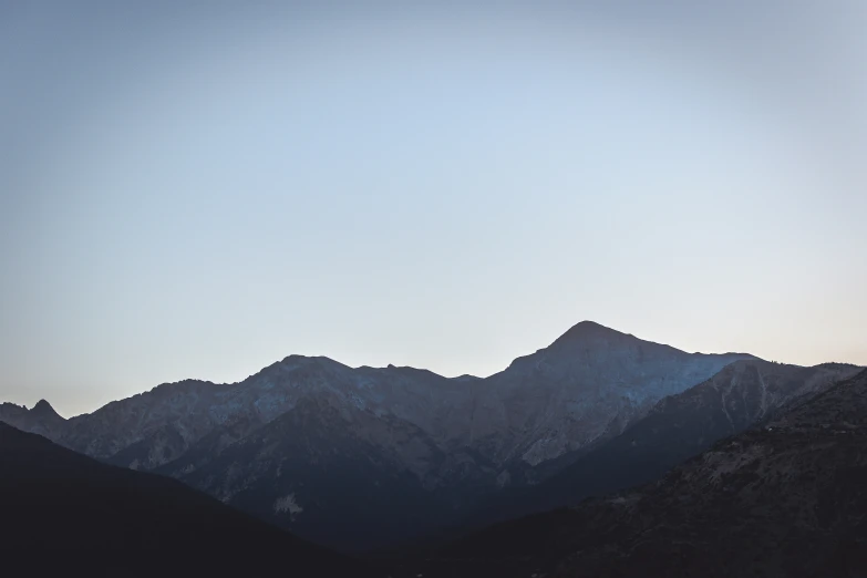 a mountain range in the distance with some clouds above