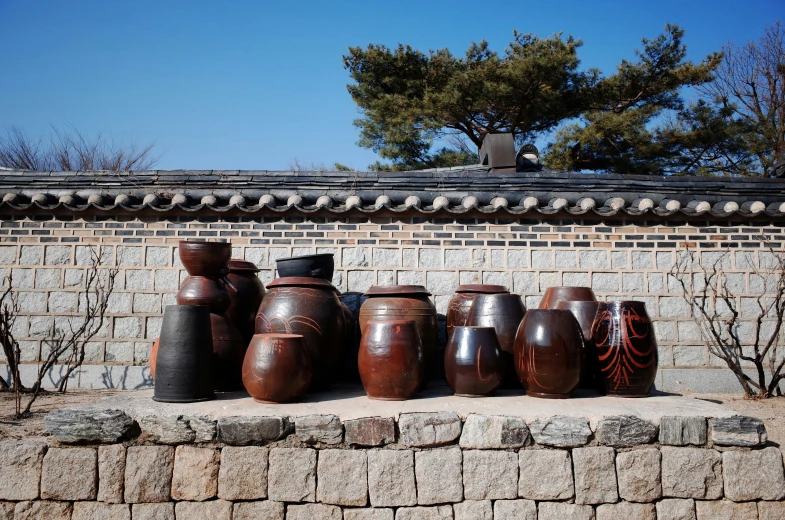 several vases sitting on top of a stone wall