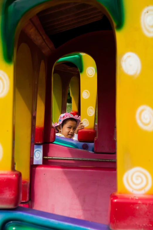 a small child in a colorful train at a carnival