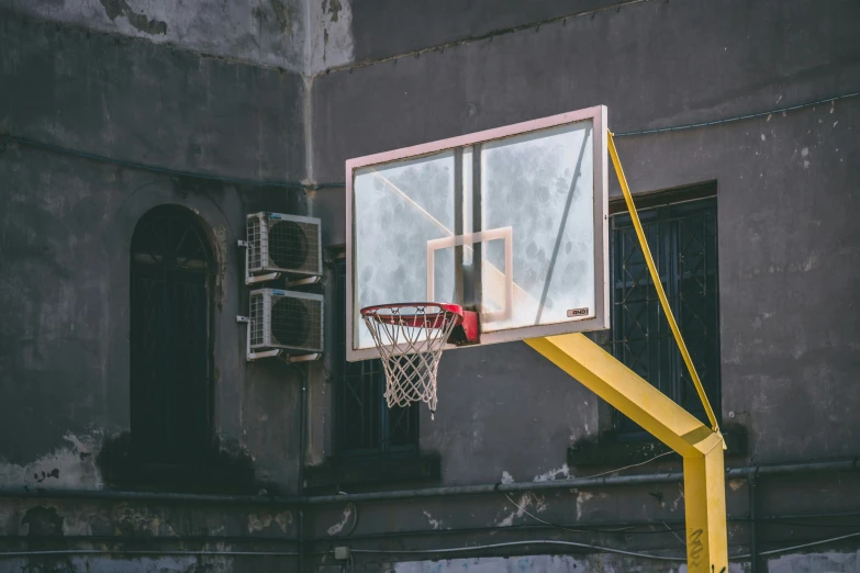 an old basketball court with a yellow hoop