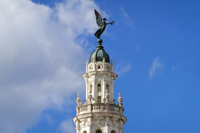 there is a clock tower with a winged bird on top