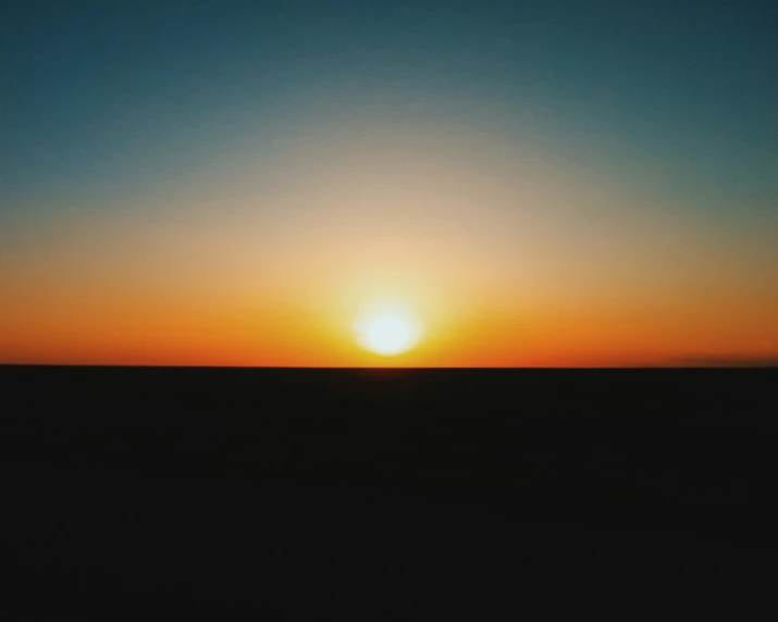 the sun rising over a vast area of land