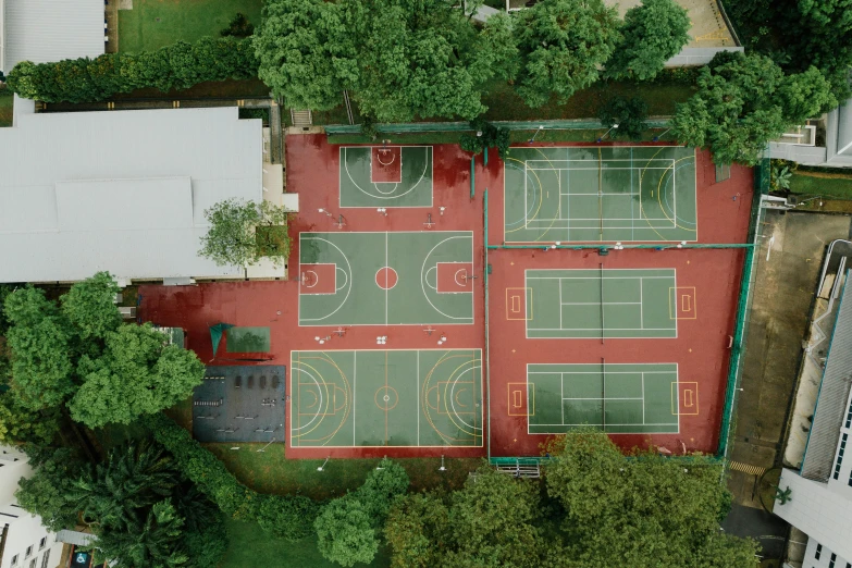 an aerial view of a tennis court surrounded by trees