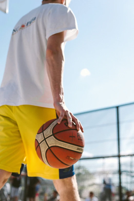 a man in yellow shorts holding a basketball