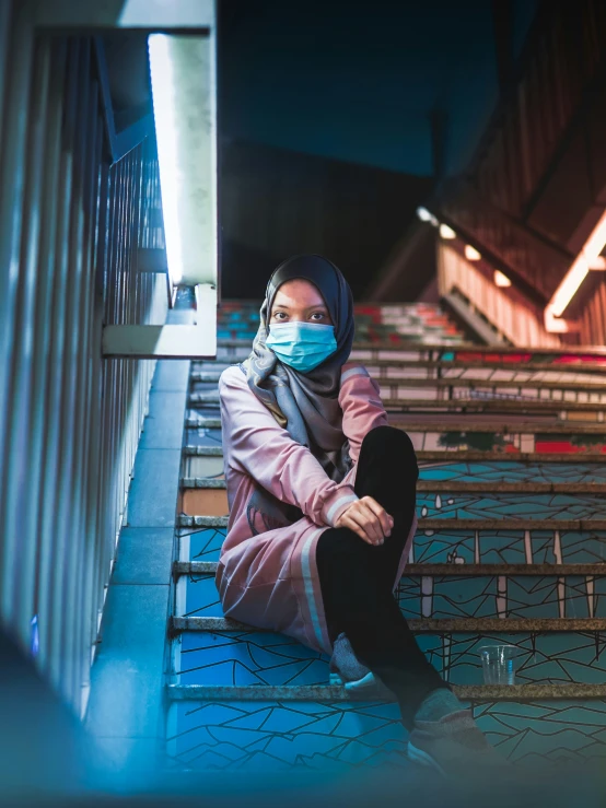 a woman in a pink shirt and a blue face mask