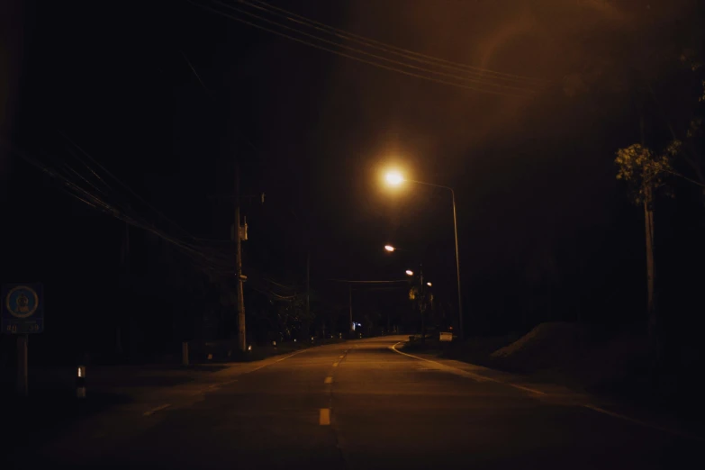 a dark street with lights shining down on it