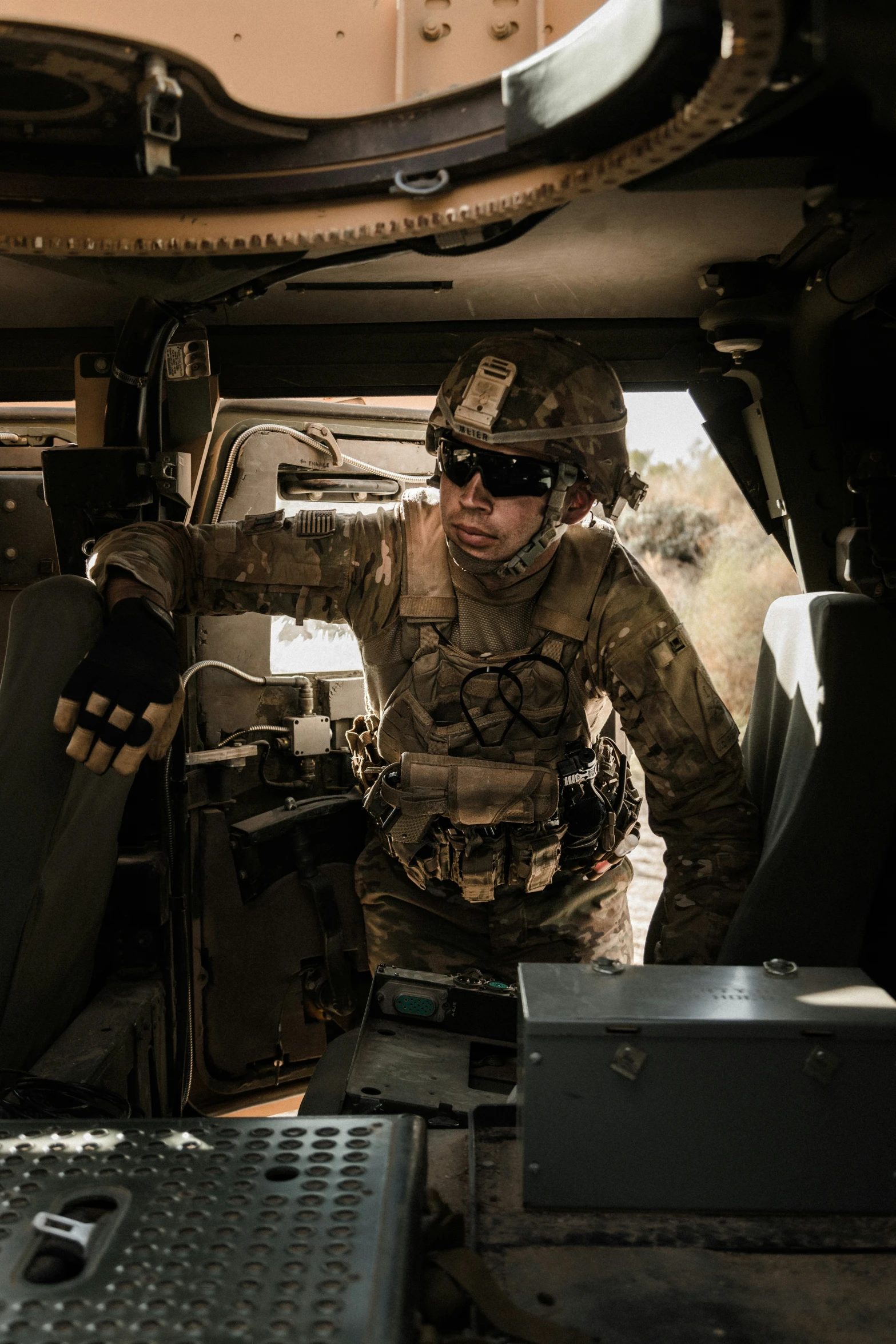 a soldier in a military vehicle with his hand up