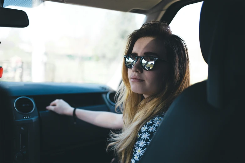 a woman sits in the drivers seat in her vehicle