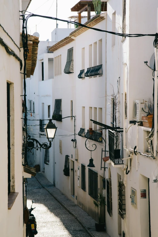 an alleyway with lots of different things hanging off the buildings