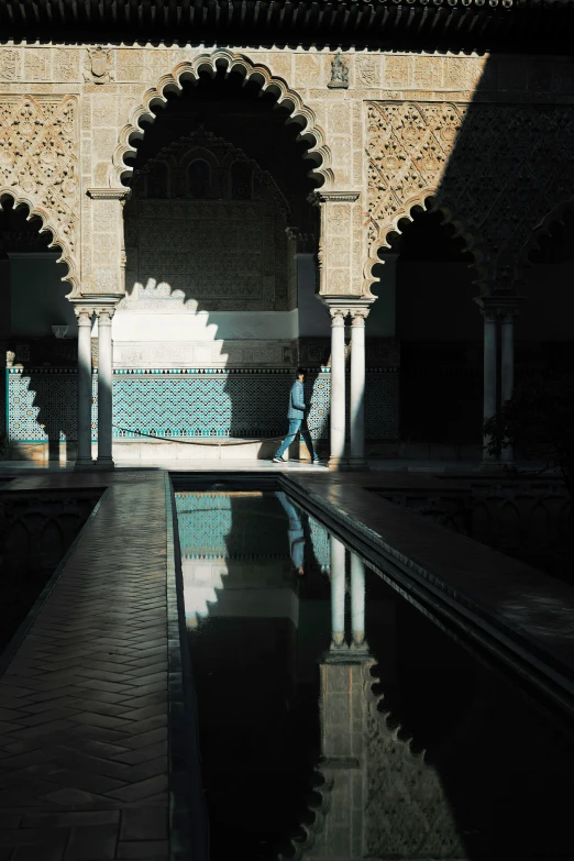 a man walks in front of the beautiful pool