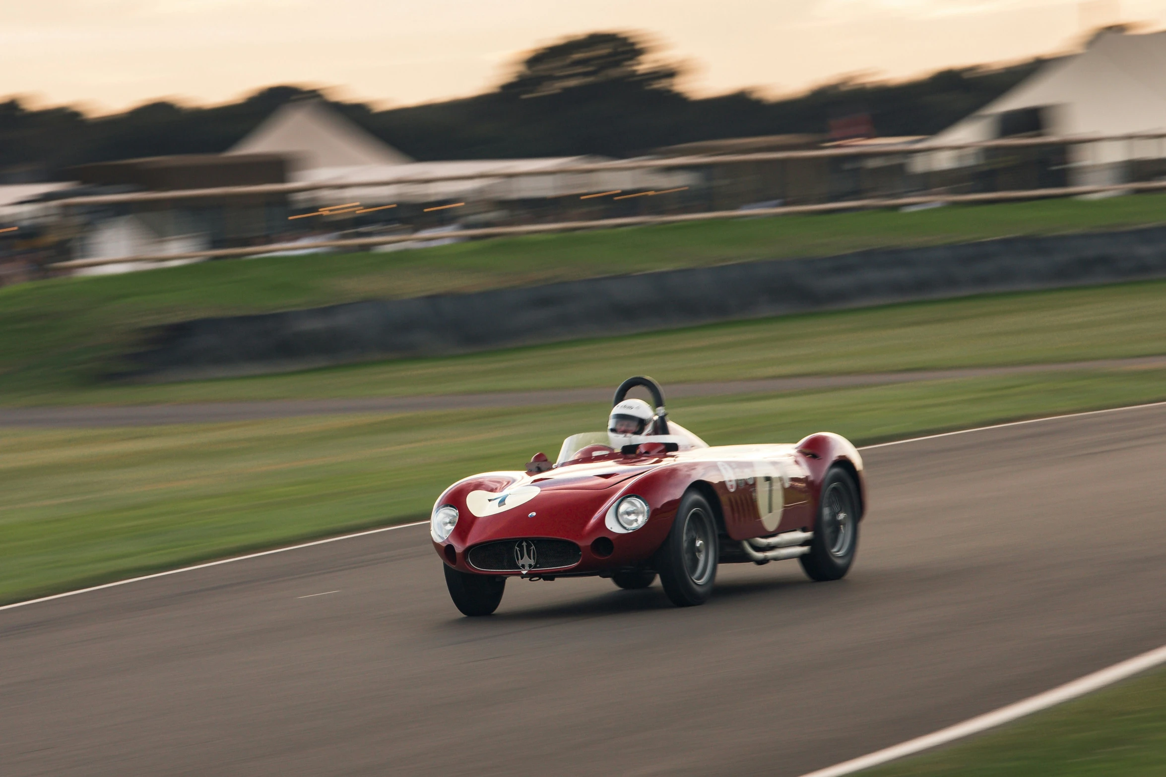 a vintage sports car speeds on a curve