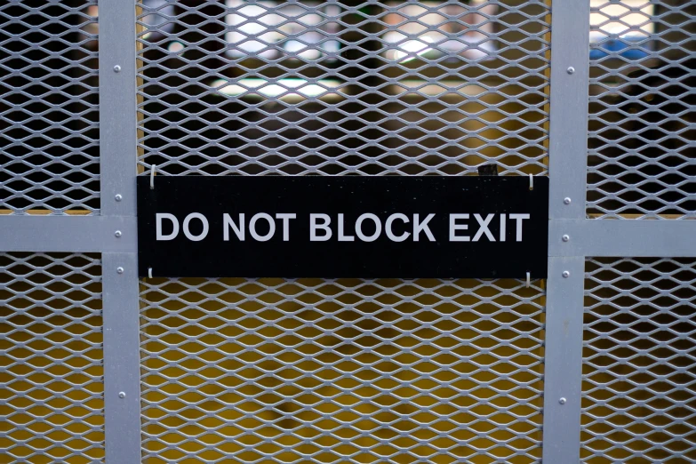 a gate with an exit sign taped to it