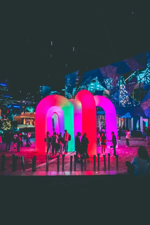 a large group of people standing in front of a colorful object