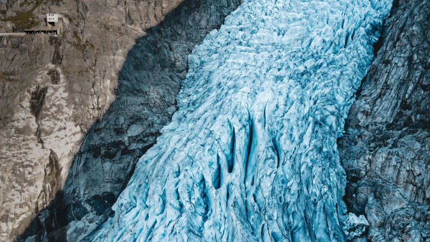 a large glacier falls into the mountains and water