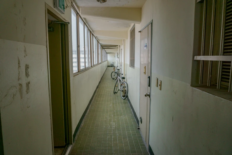 a view down a narrow hallway with three bicycles parked on the floor