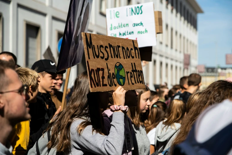 a protest holds up signs as people stand in a street