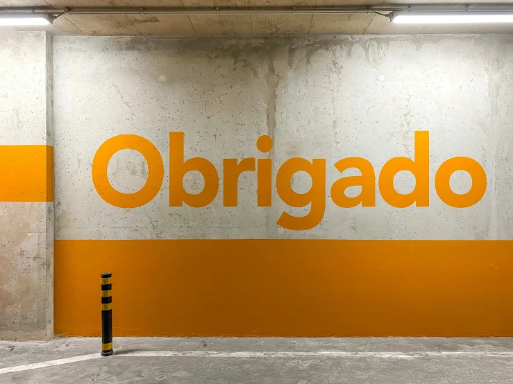 an orange and white sign reads obrigado next to a fire hydrant